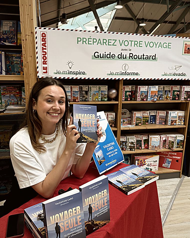 Valentine au stand du Guide du Routard, son livre à la main