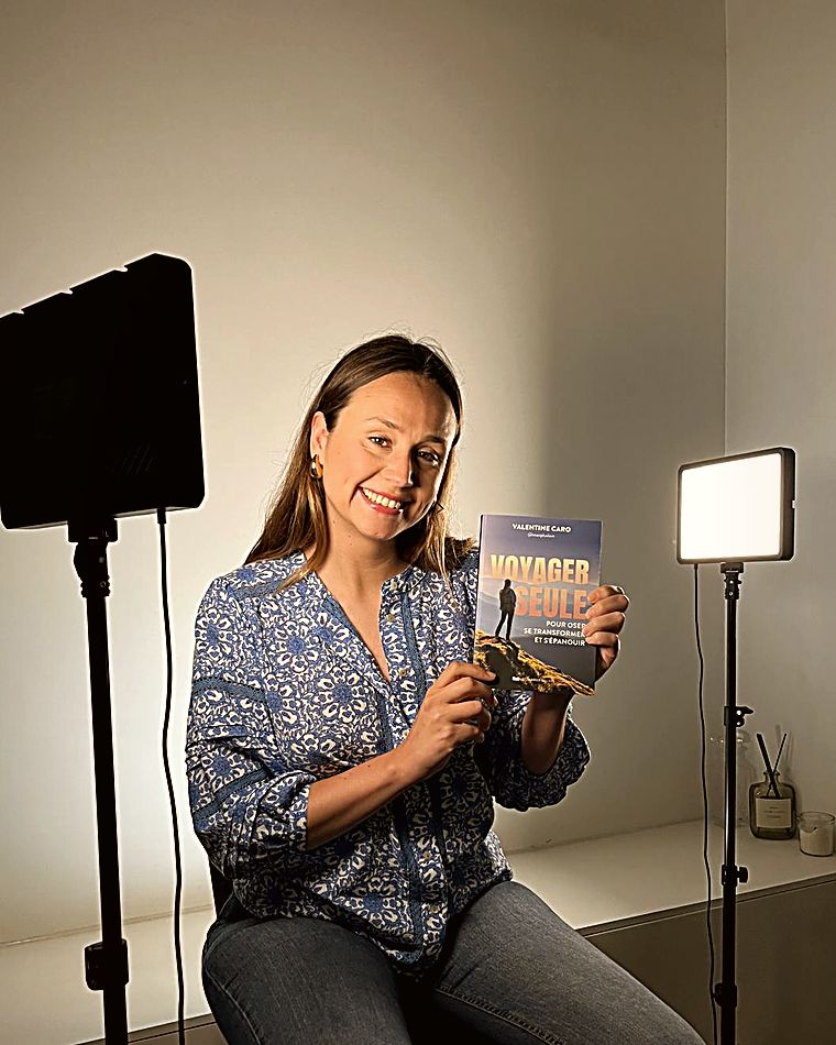 Valentine, en studio, son livre « Voyager seule » à la main